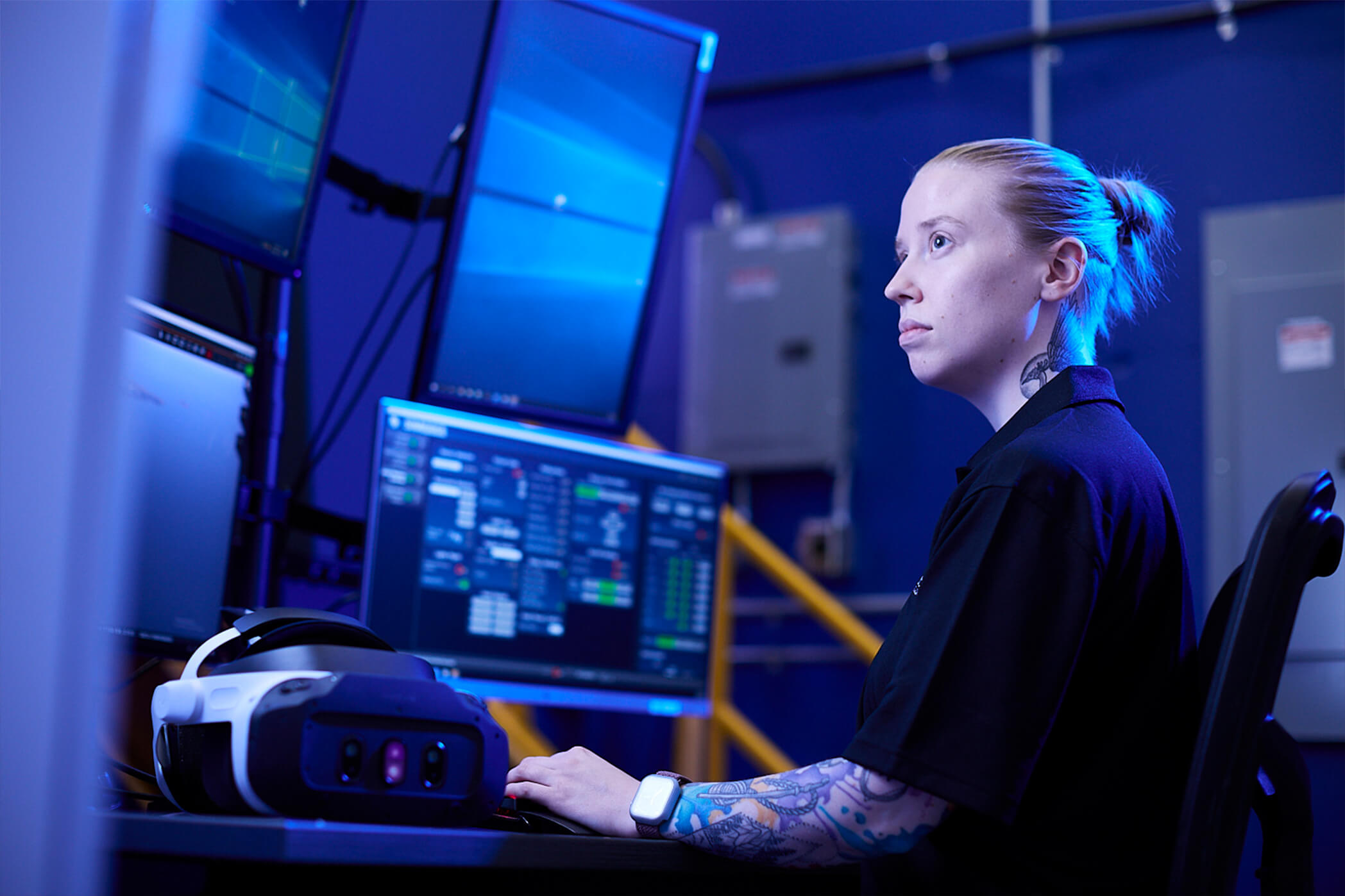 Bucket Image. Tattooed young woman at computer workstation